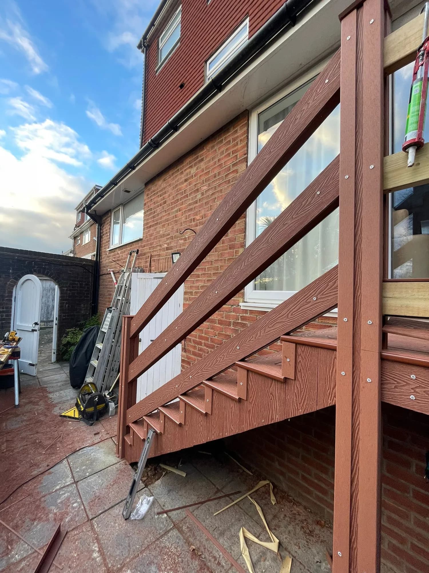 Composite deck with wrapped fascia and matching stairs stepping down from a first-floor door